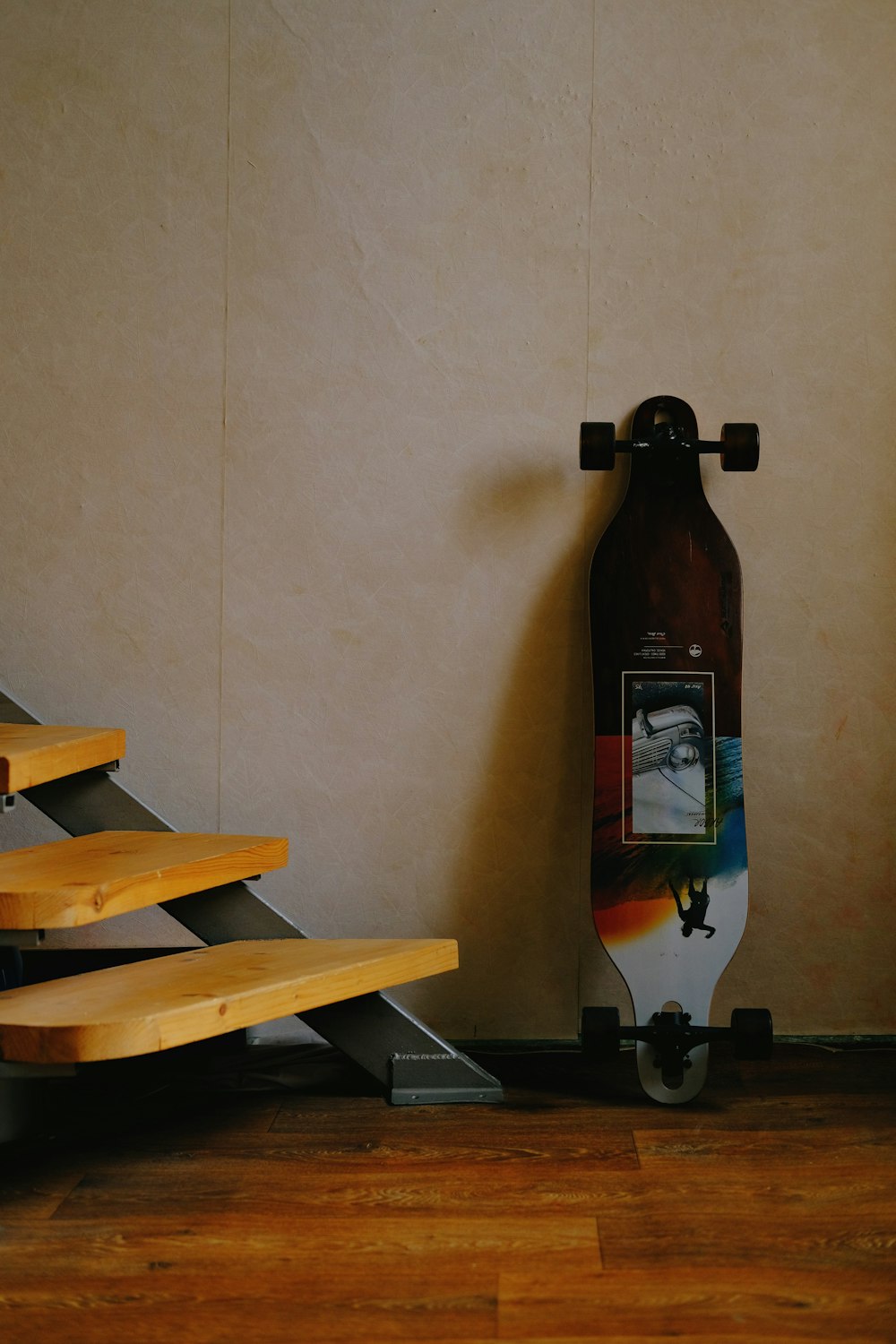 a skateboard leaning against a wall next to a set of stairs