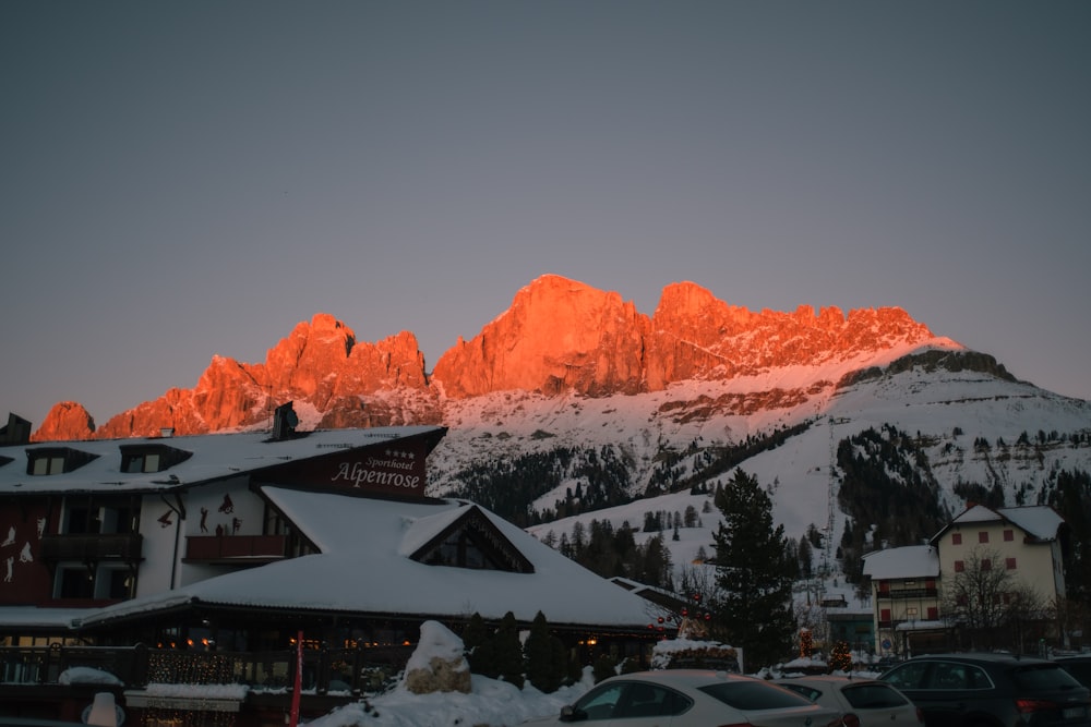 a snow covered mountain with cars parked in front of it