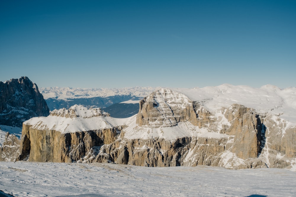 a mountain range covered in snow with mountains in the background