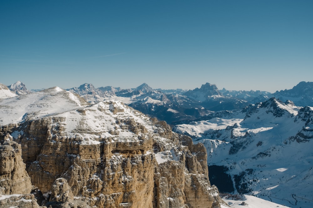 a mountain range covered in snow with mountains in the background