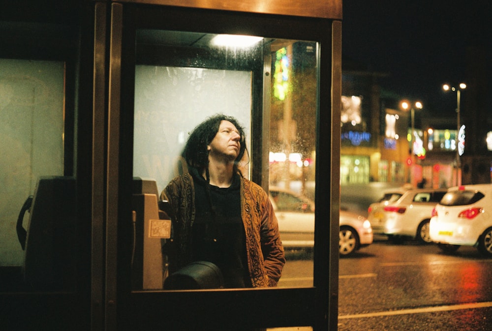 a man standing on a bus stop next to a street