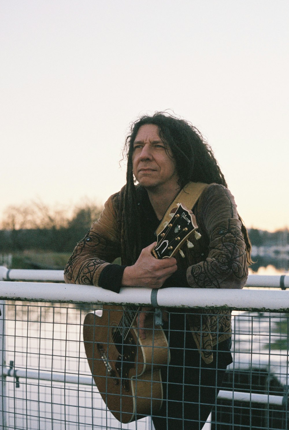 a man with long hair holding a guitar