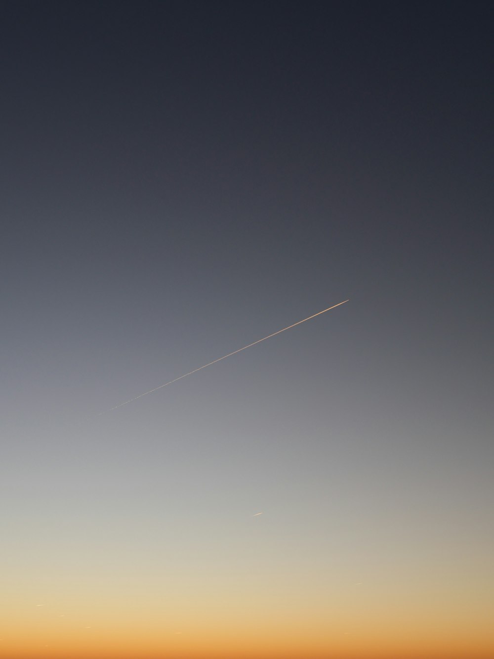 a plane is flying in the sky at sunset
