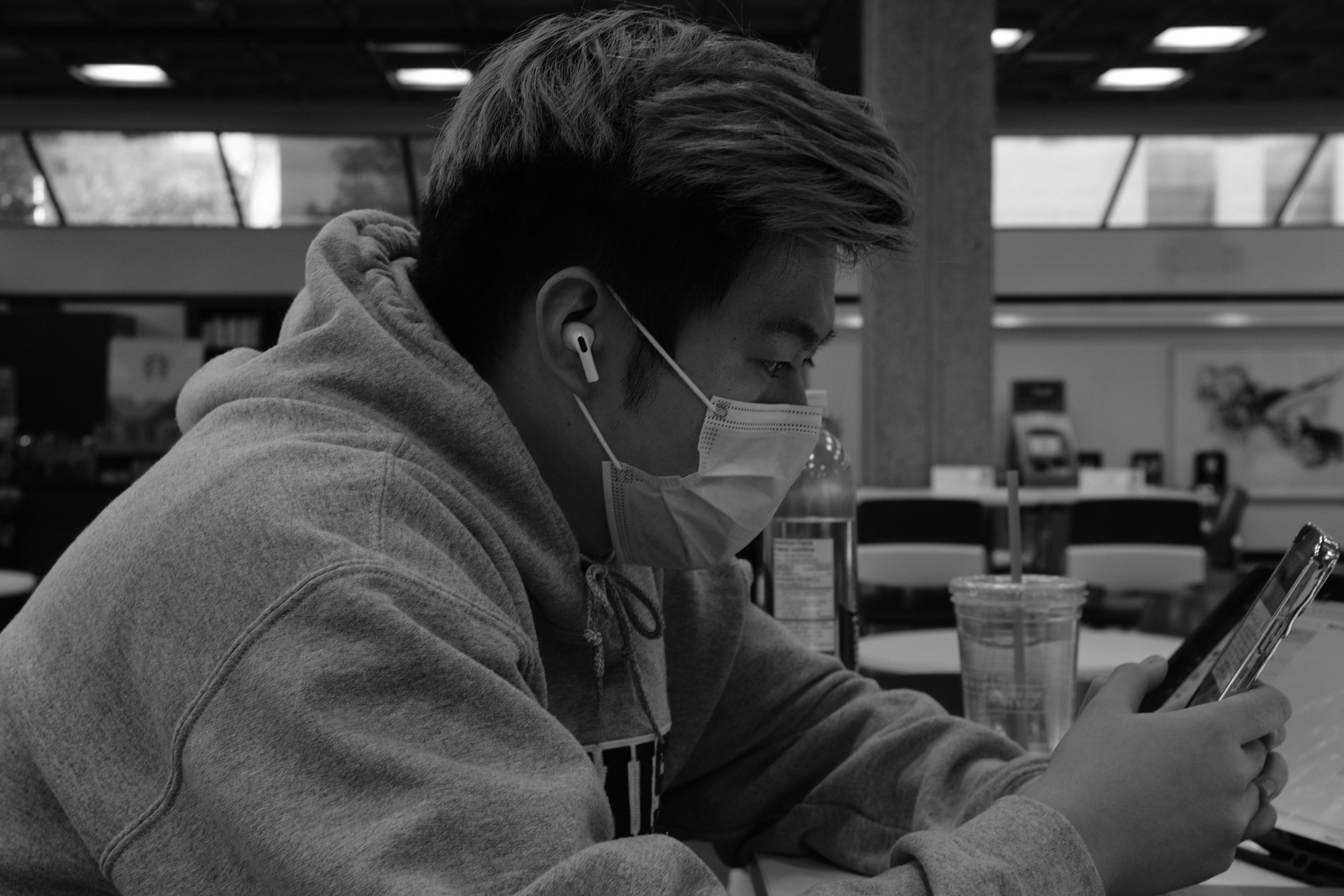 a man wearing a face mask while looking at his cell phone
