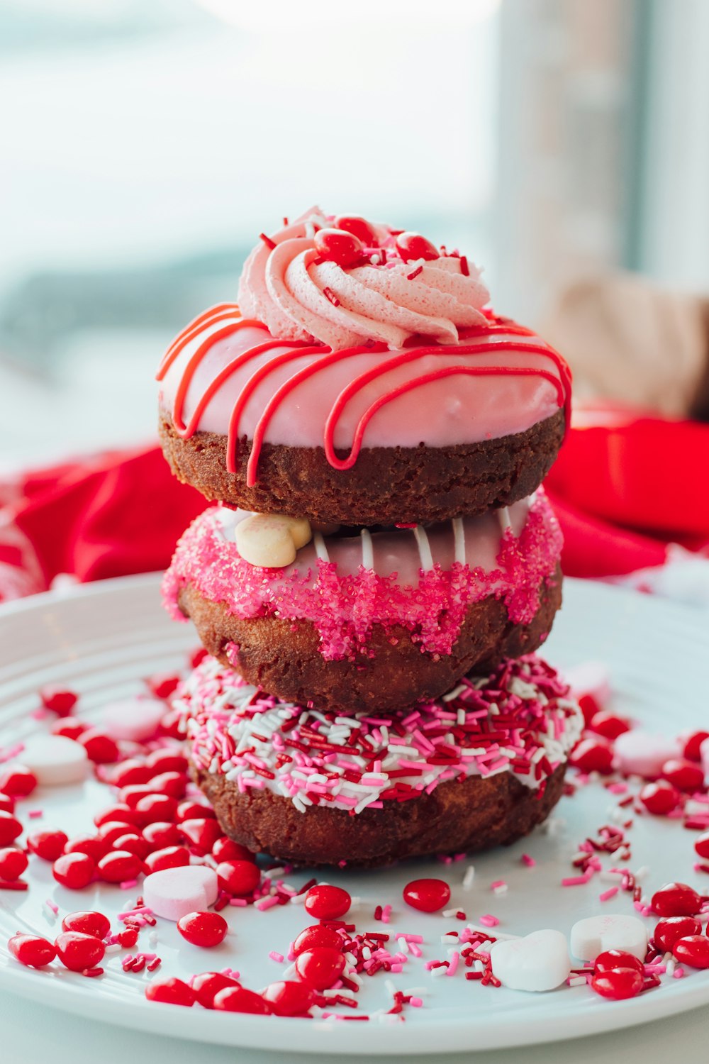 a white plate topped with three donuts covered in frosting and sprinkle