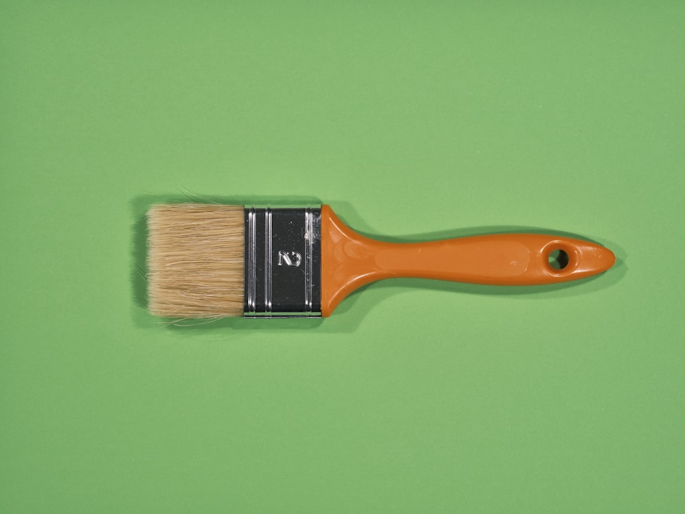 a paint brush with a brown bristles on a green background