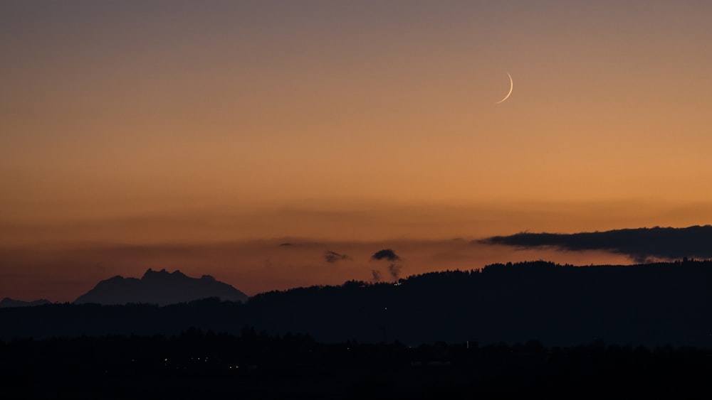 the sun is setting over a mountain range