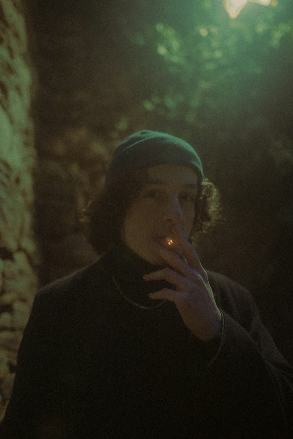 a young man smoking a cigarette in the dark