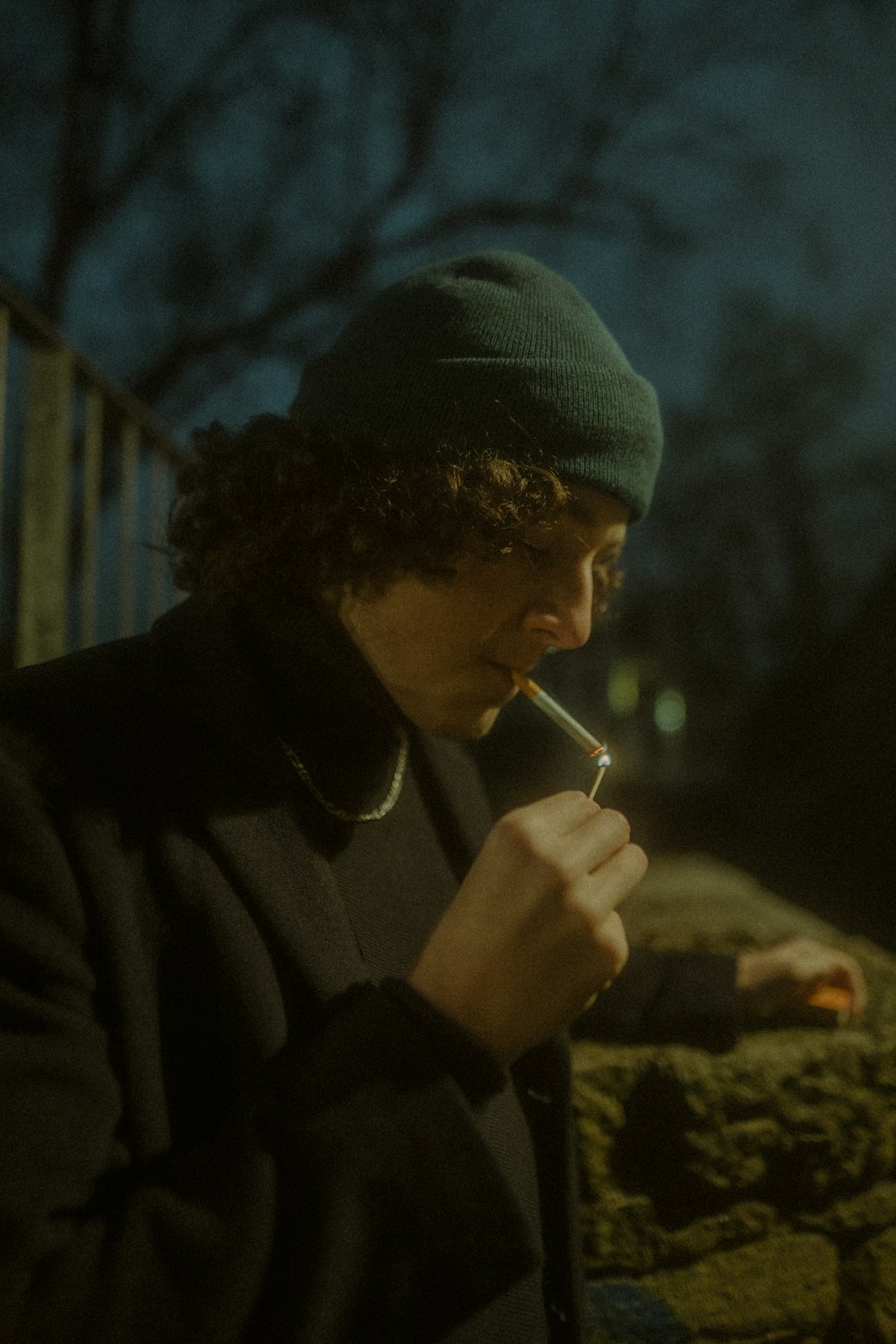 a man smoking a cigarette in the dark