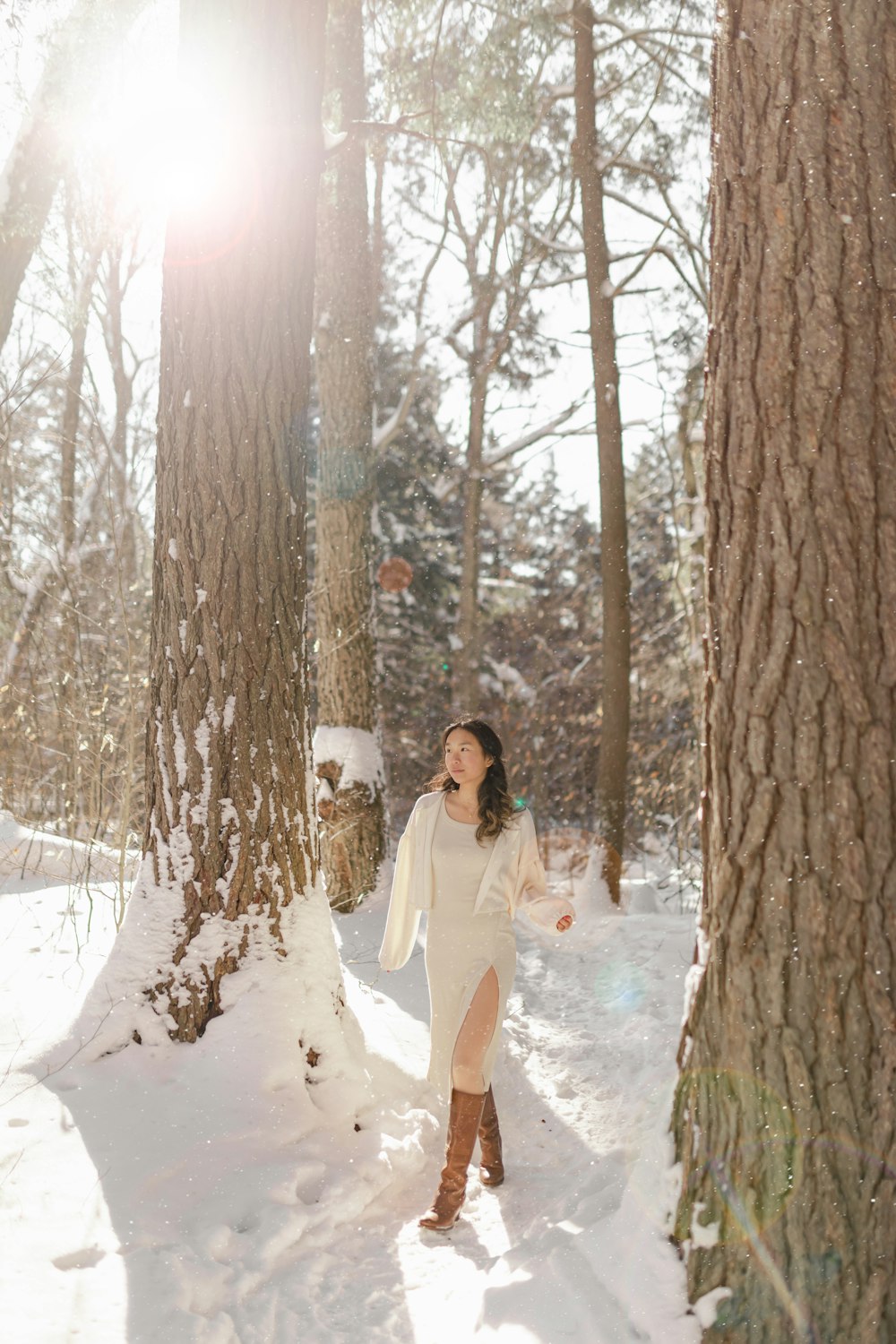 a woman in a white dress standing in the snow