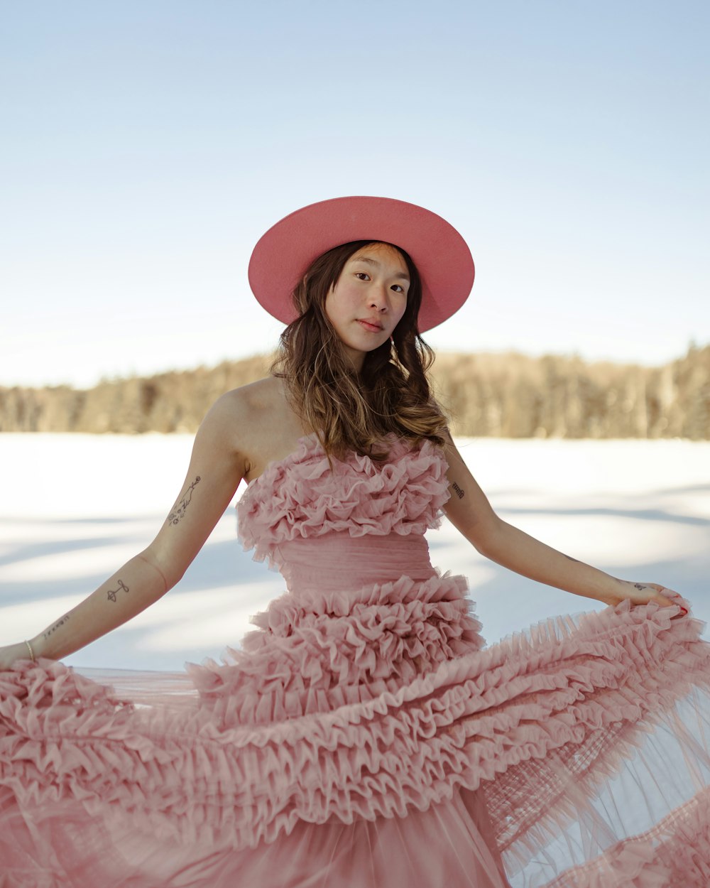 a woman wearing a pink dress and a pink hat