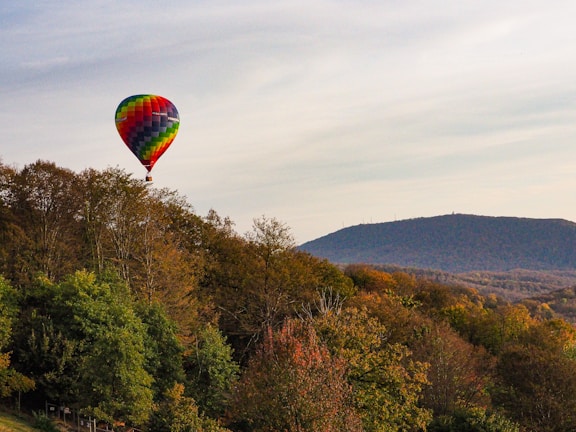 A vibrant image of a hot air balloon flying over a scenic landscape.