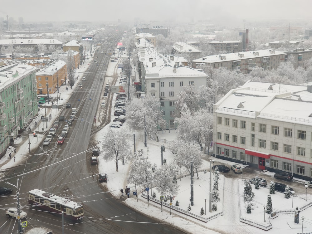 a snowy city street with cars and buses