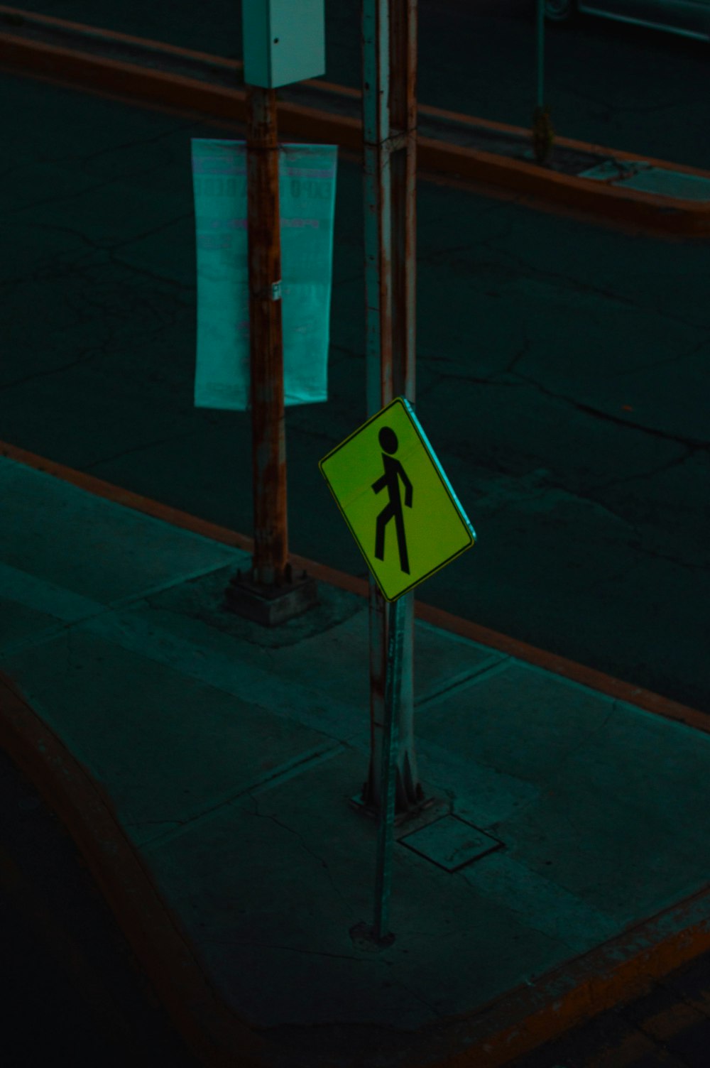 a pedestrian crossing sign on a city street