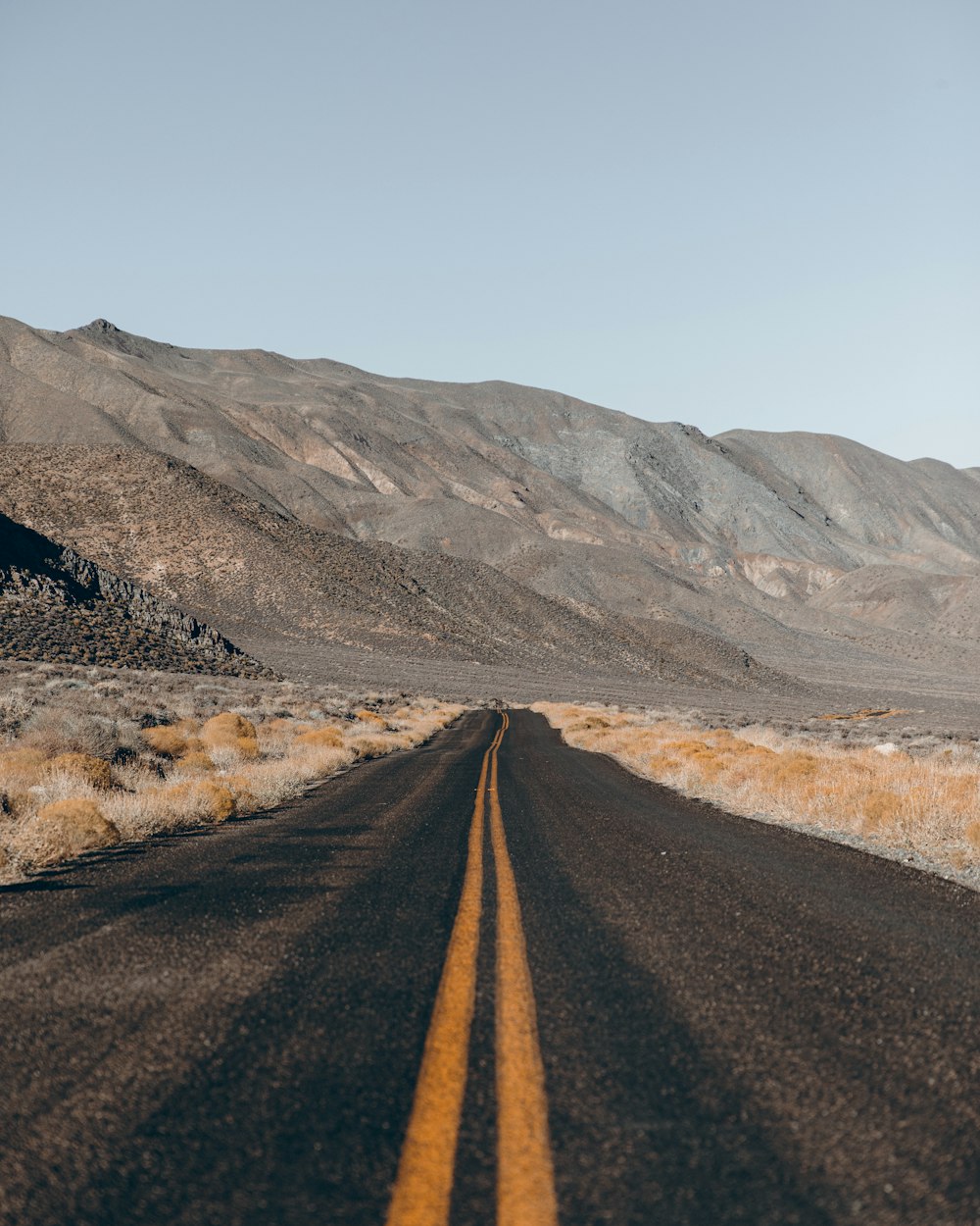 a highway with a mountain in the middle of a dirt road