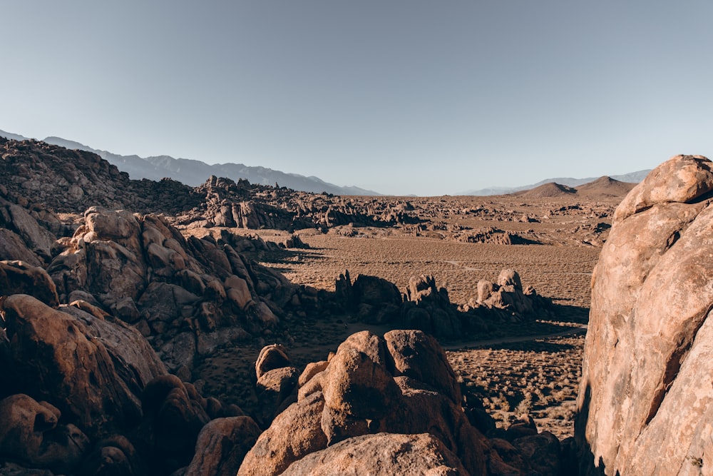 a rocky landscape with mountains in the background