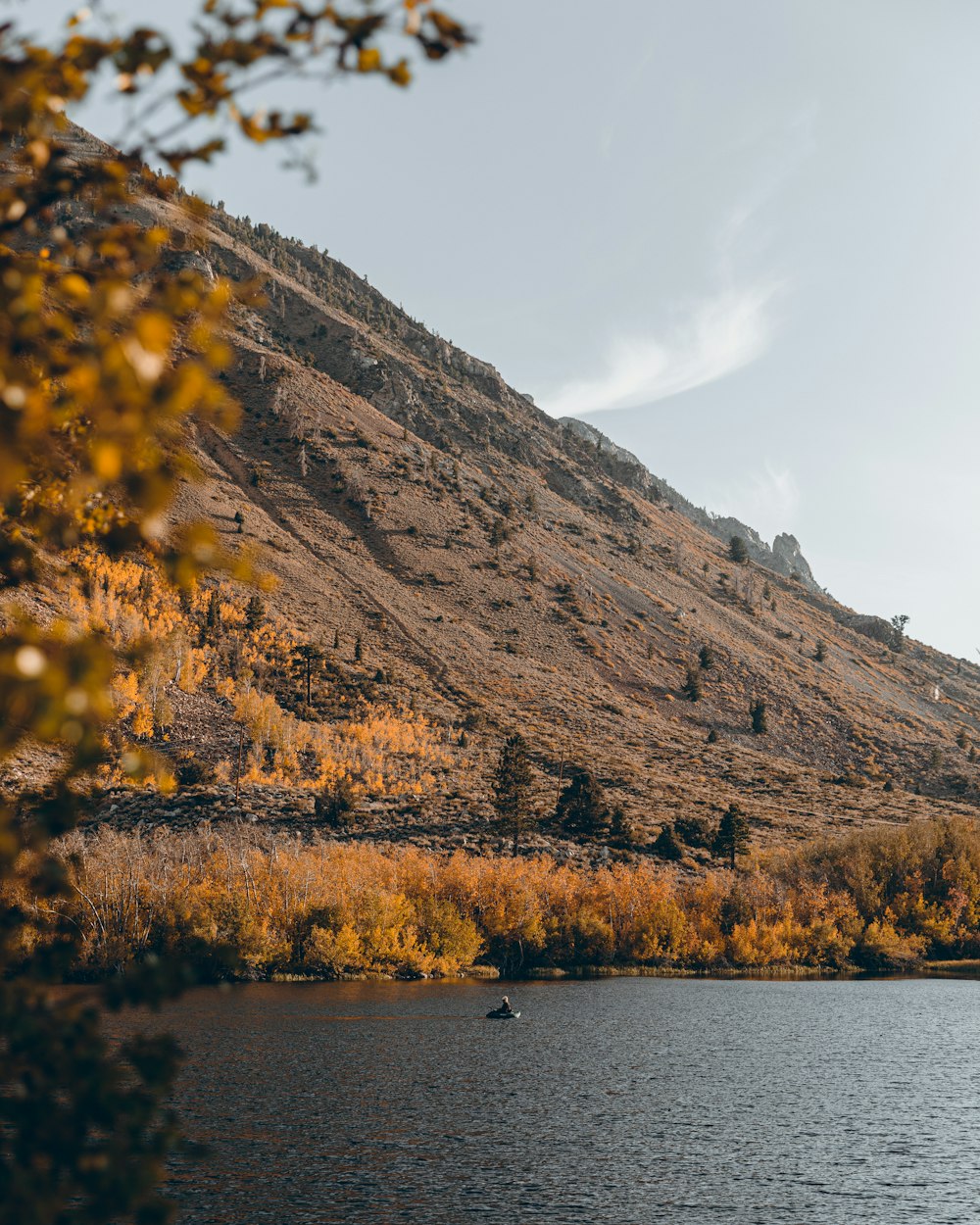 a boat floating on top of a lake next to a mountain