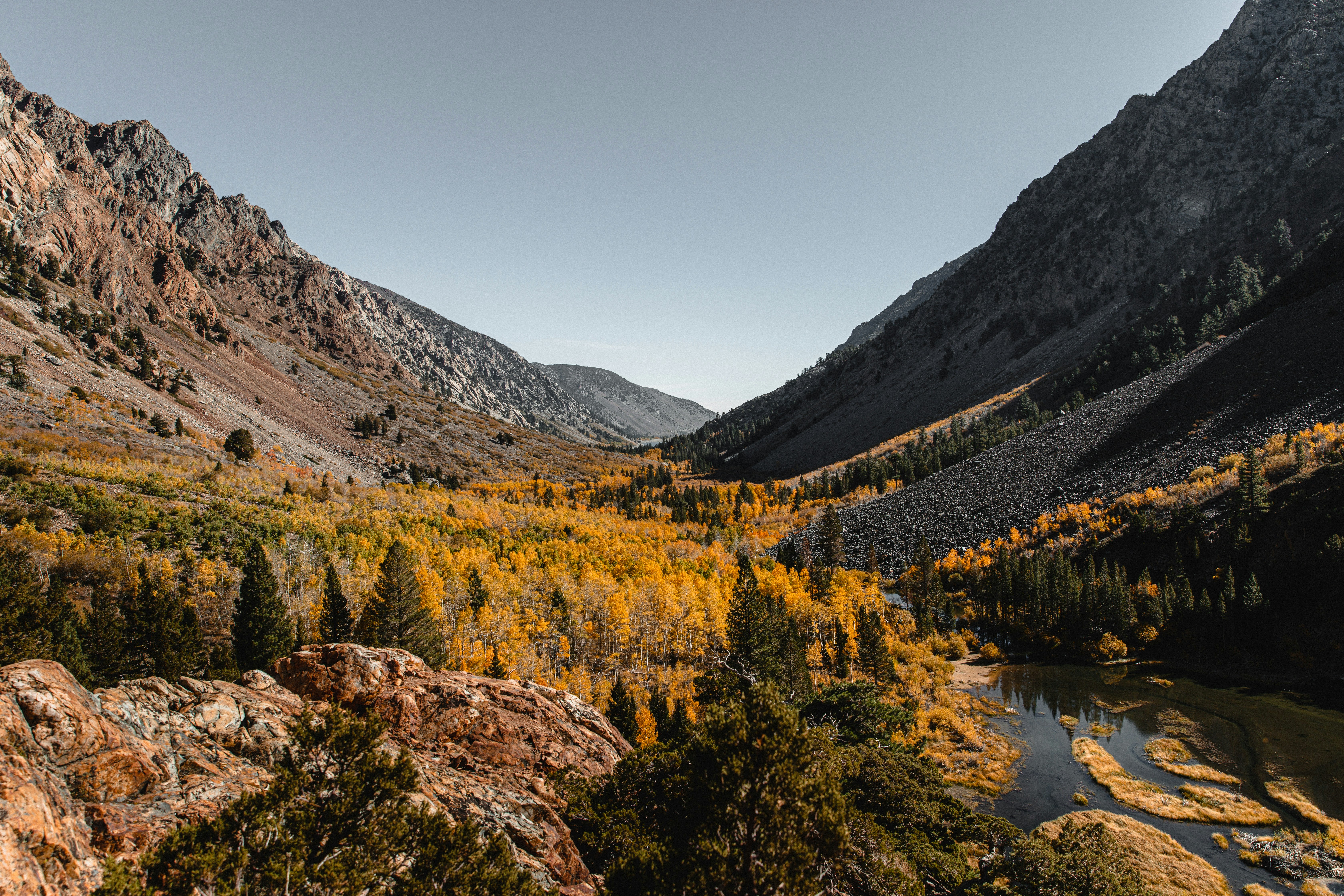 a river in a valley surrounded by mountains