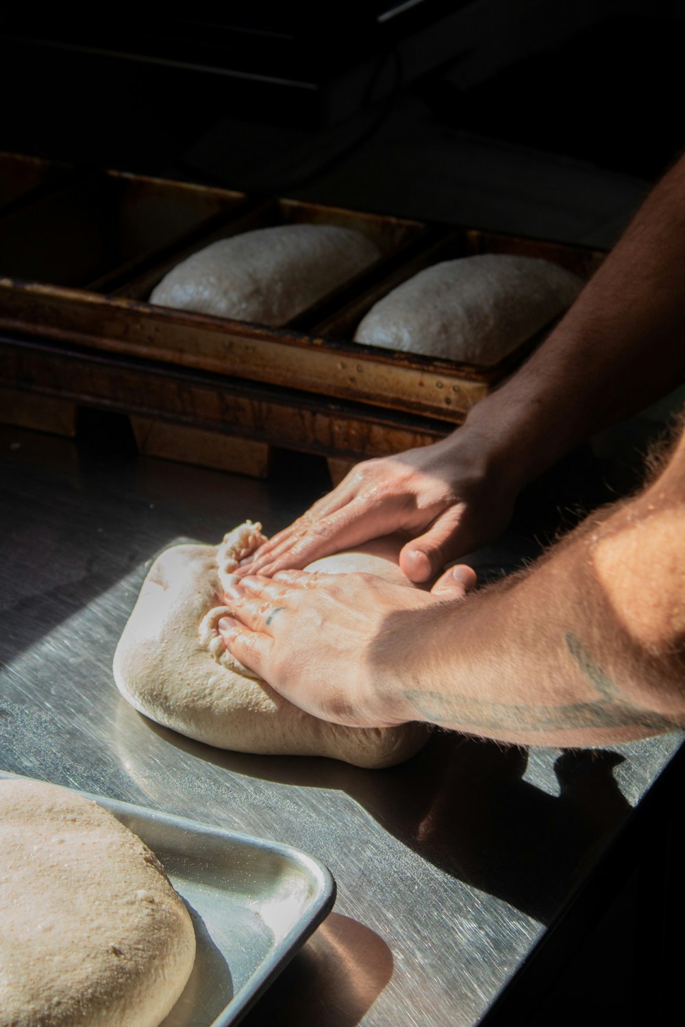 a person is kneading dough into a loaf of bread