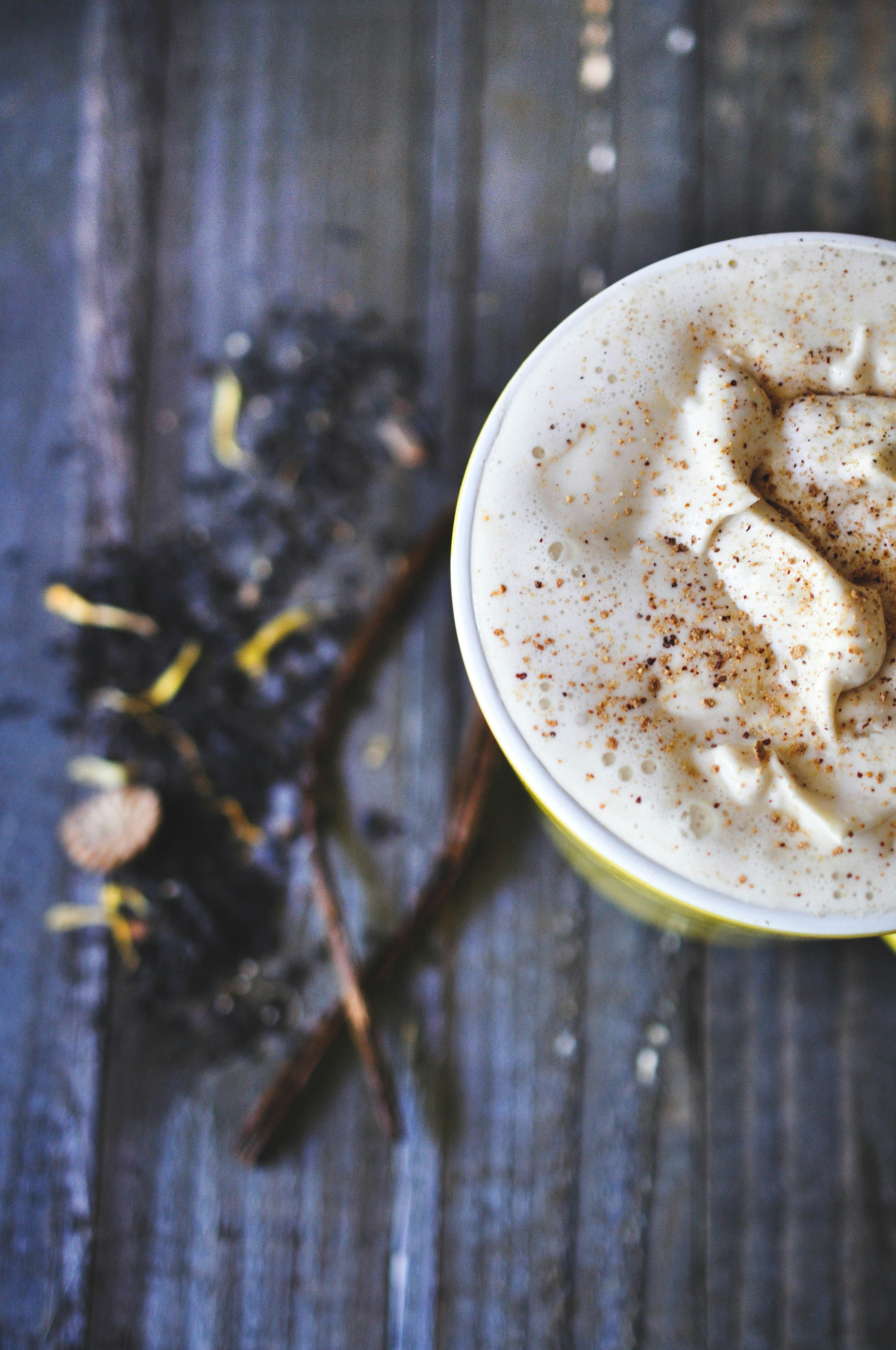 a cup of coffee with cinnamon on a wooden table