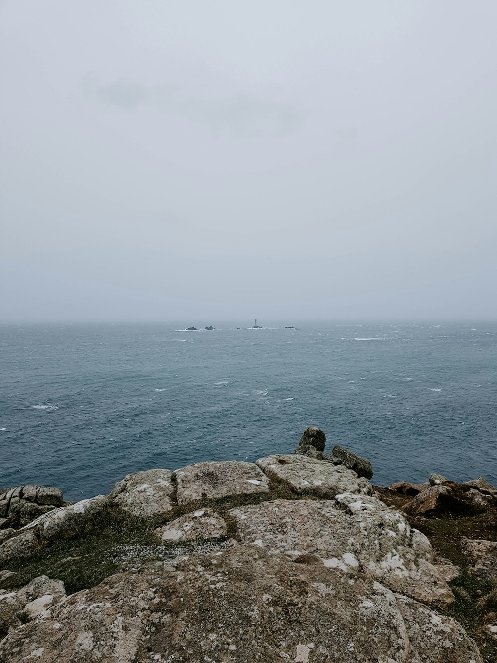 a large body of water sitting next to a rocky shore