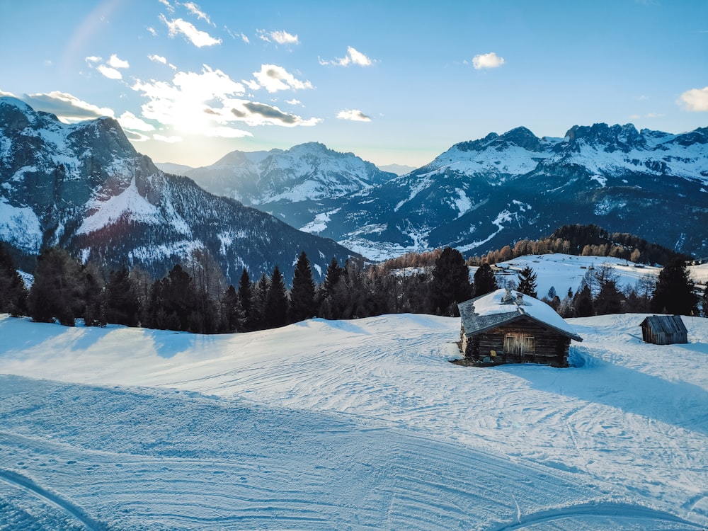 a cabin in the middle of a snowy mountain range