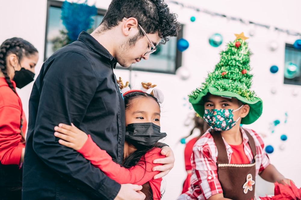 a group of people standing around each other wearing masks