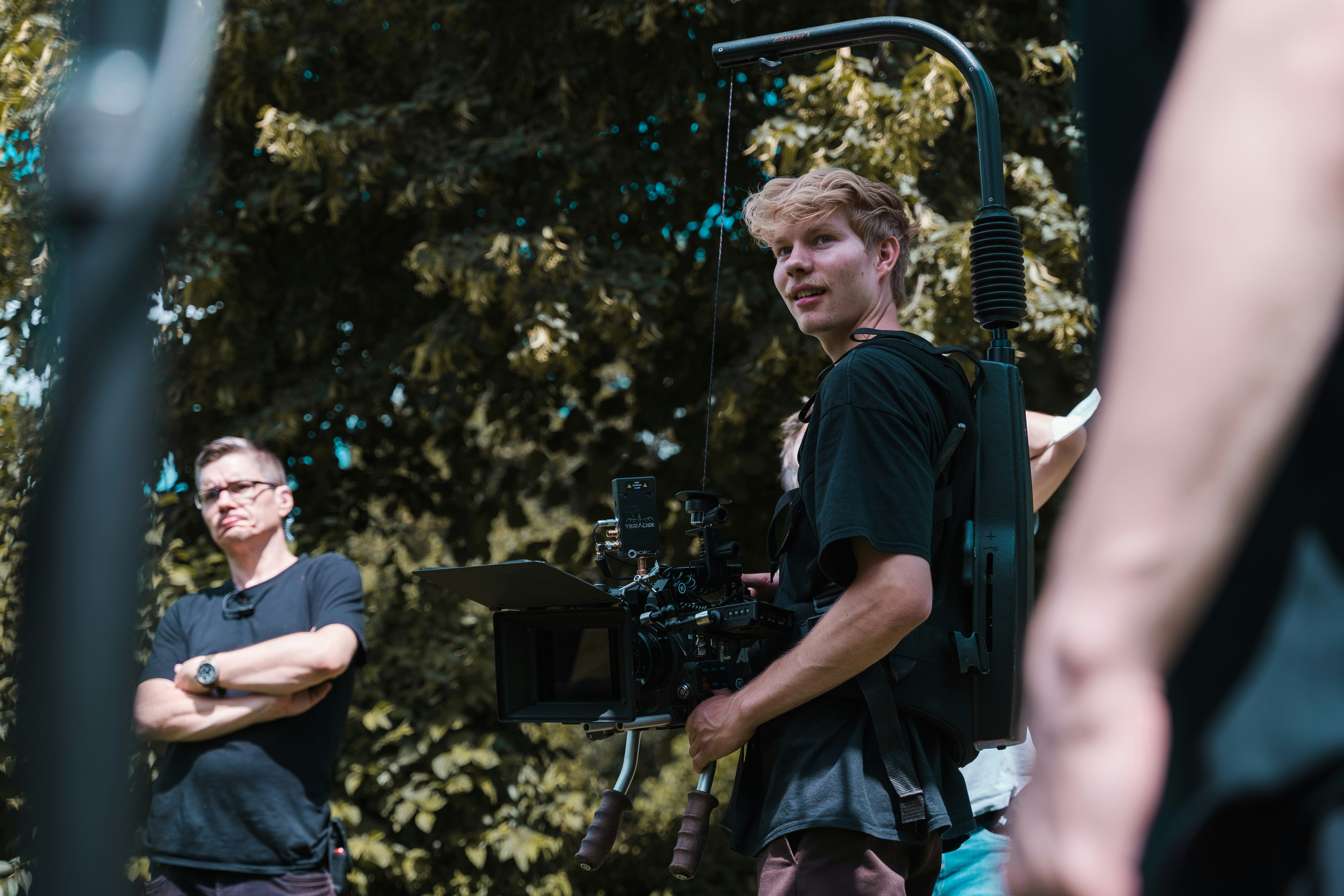 a man standing next to another man holding a camera