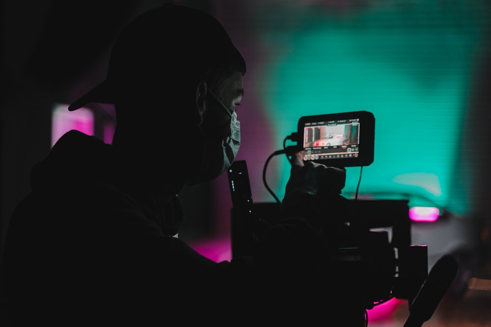 a man holding a camera in front of a green screen