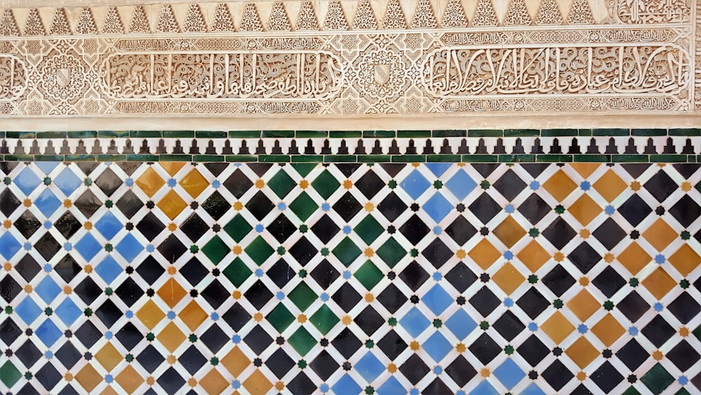 a colorful tile wall with arabic writing on it