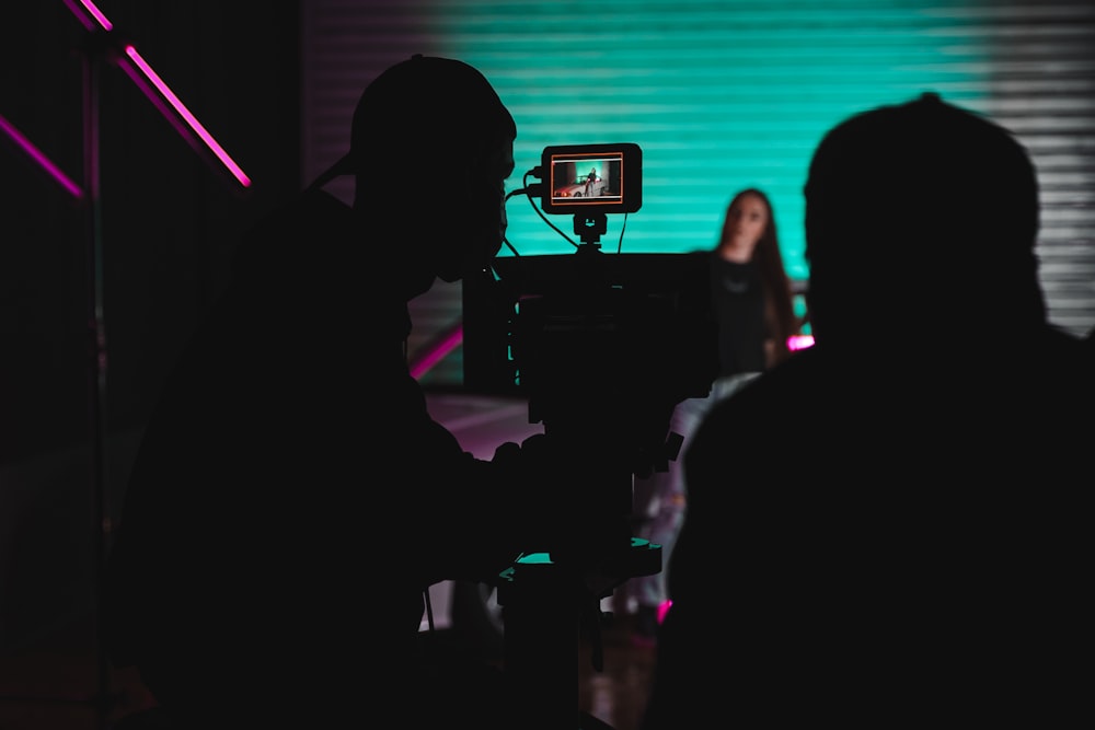 a person standing in front of a camera in a dark room