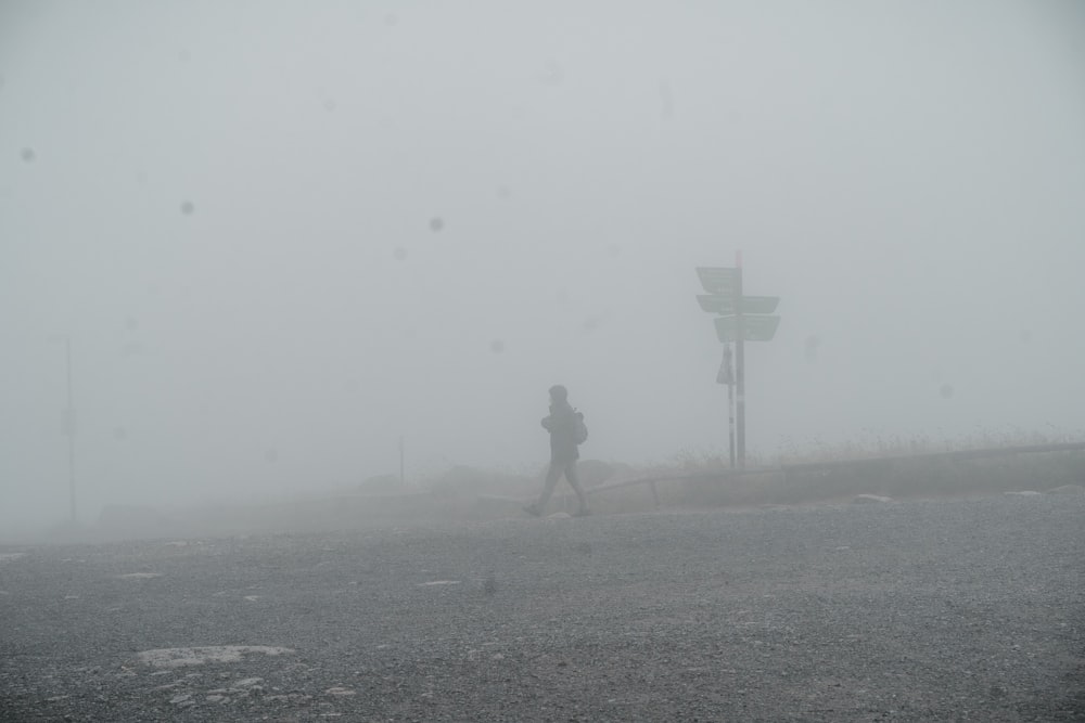 Una persona che cammina lungo una strada nella nebbia