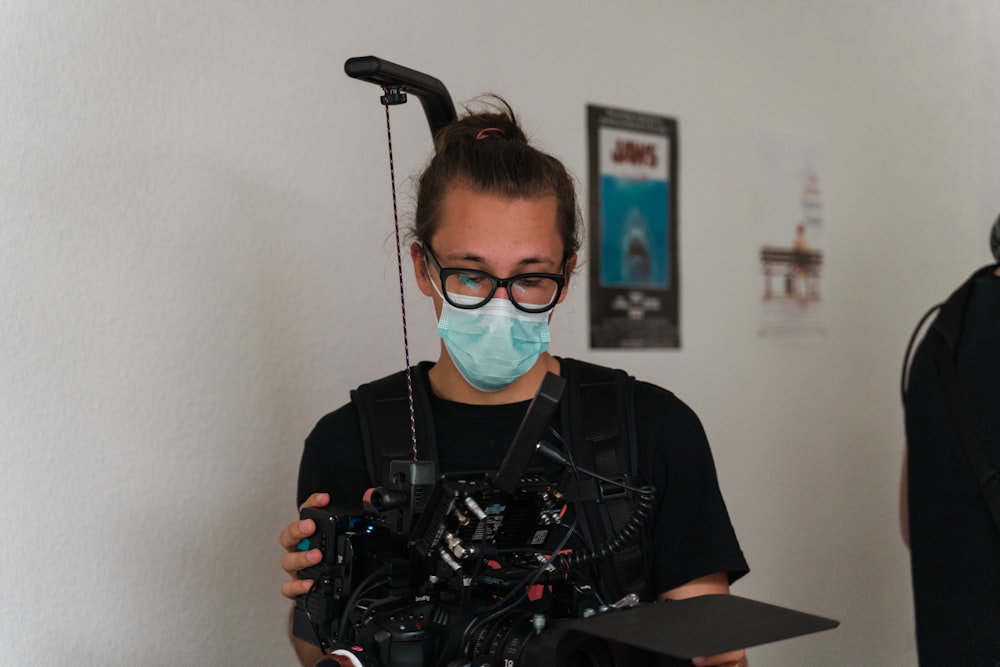 a woman wearing a face mask holding a camera