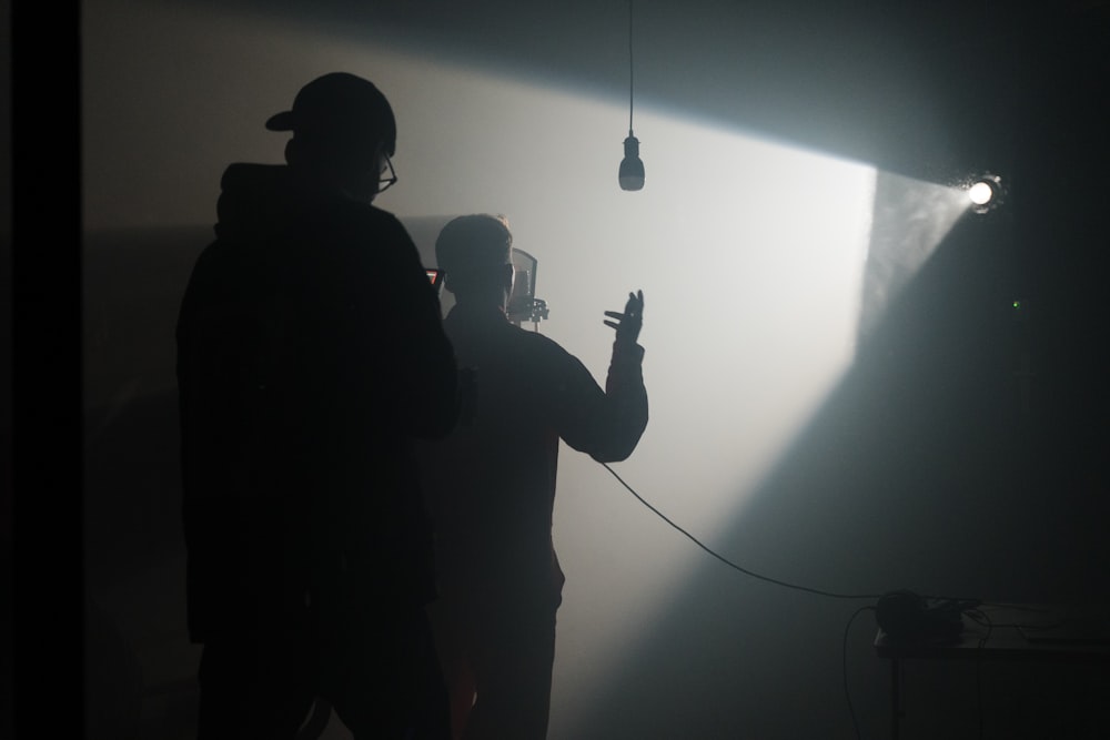 a man standing in a dark room holding a microphone