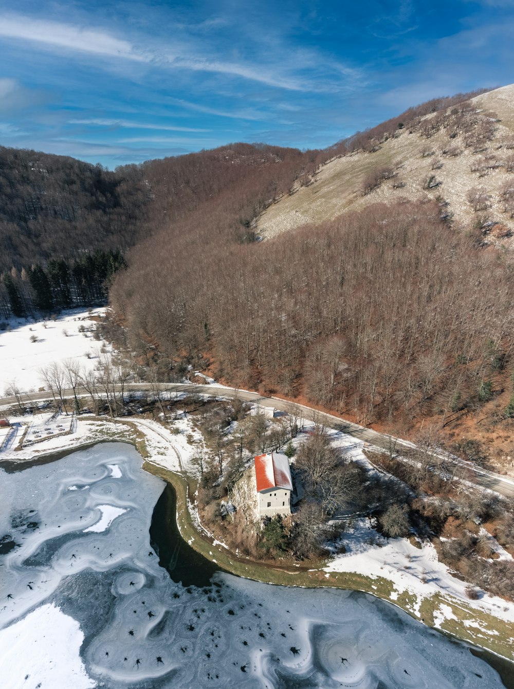 an aerial view of a small house in the middle of a snowy field