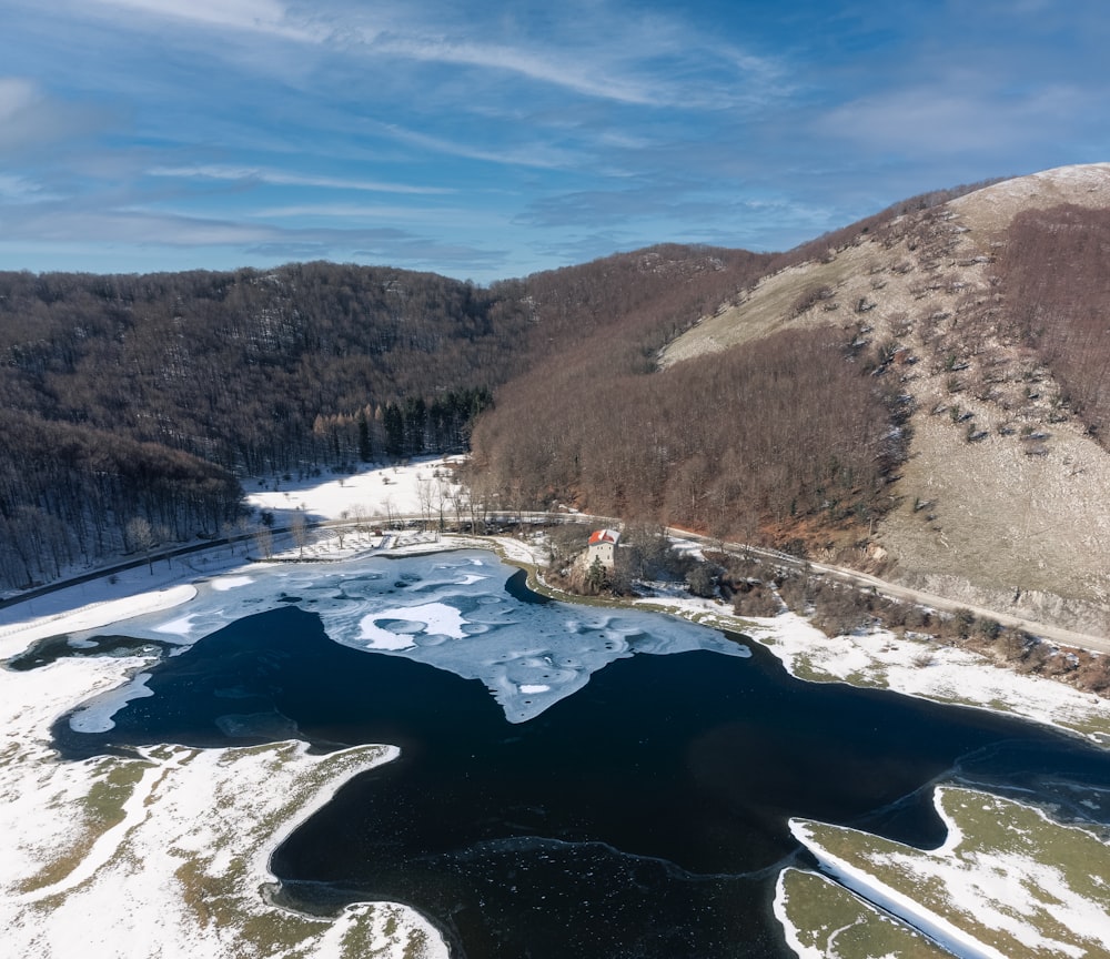 an aerial view of a lake surrounded by mountains