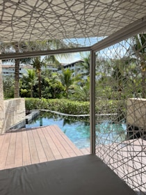A beautifully restored teak deck overlooking a serene pool at a boutique hotel.