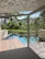 Elegant wooden deck and pergola surrounded by lush greenery.