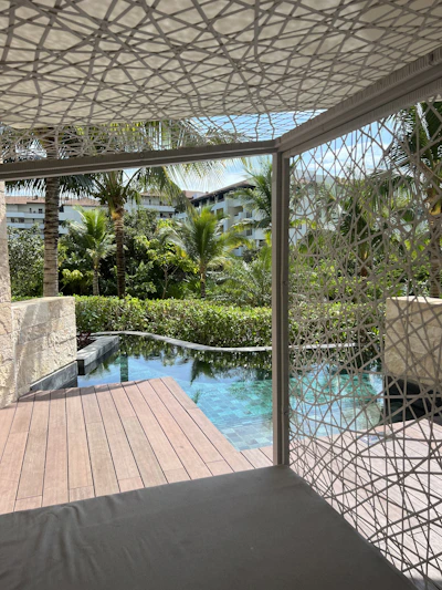 A beautifully crafted pool deck with integrated lighting and lush greenery surrounding it at sunset.