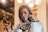 a woman talking on a cell phone while holding a cup of coffee