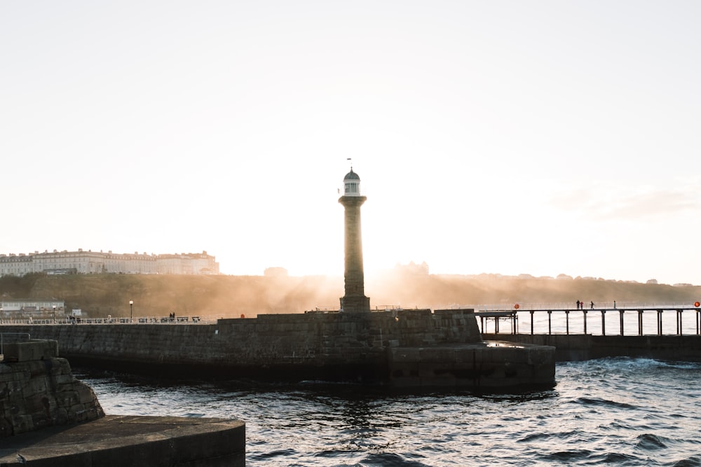 a light house sitting on top of a pier next to a body of water