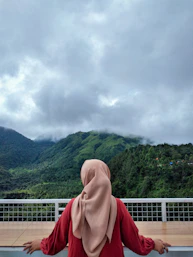 a woman in a hijab standing on a balcony
