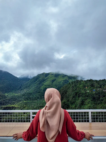 a woman in a hijab standing on a balcony