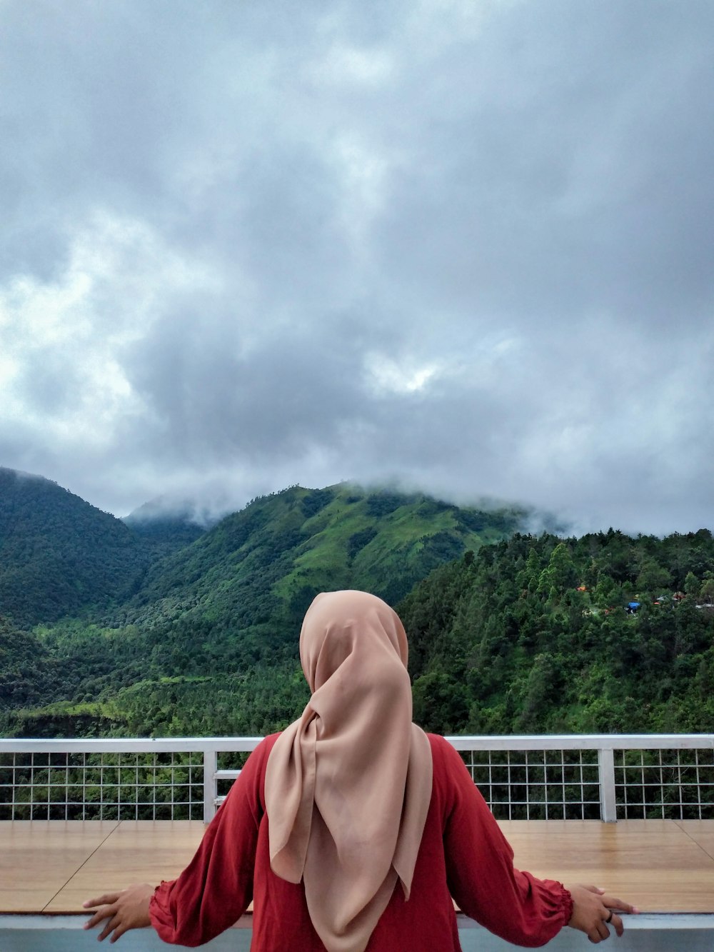 a woman in a hijab standing on a balcony