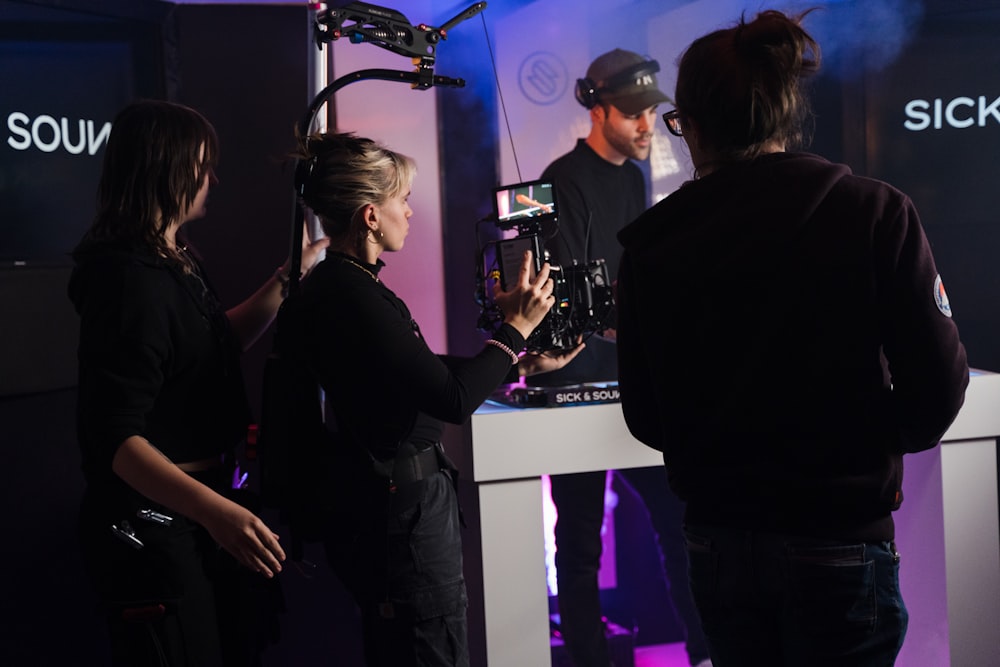 a group of people standing around a table with a camera