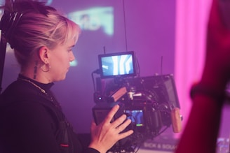 a woman holding a camera in front of a tv