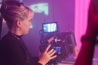 a woman holding a camera in front of a tv