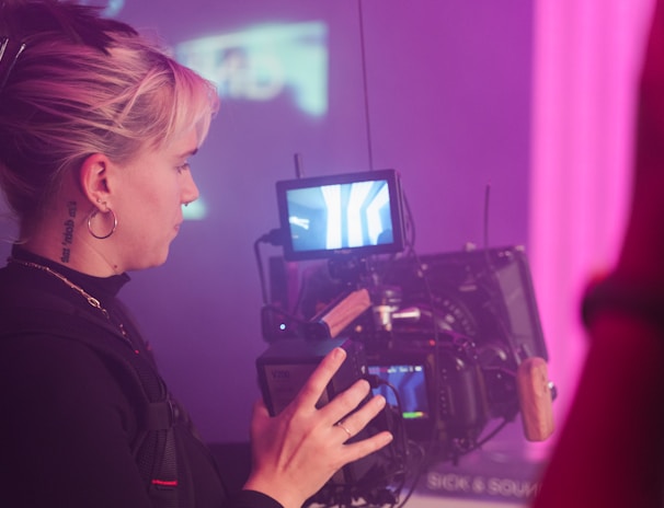 a woman holding a camera in front of a tv