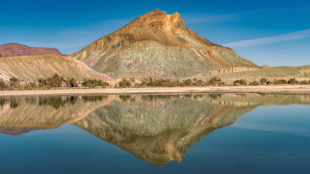 a mountain is reflected in the still water of a lake