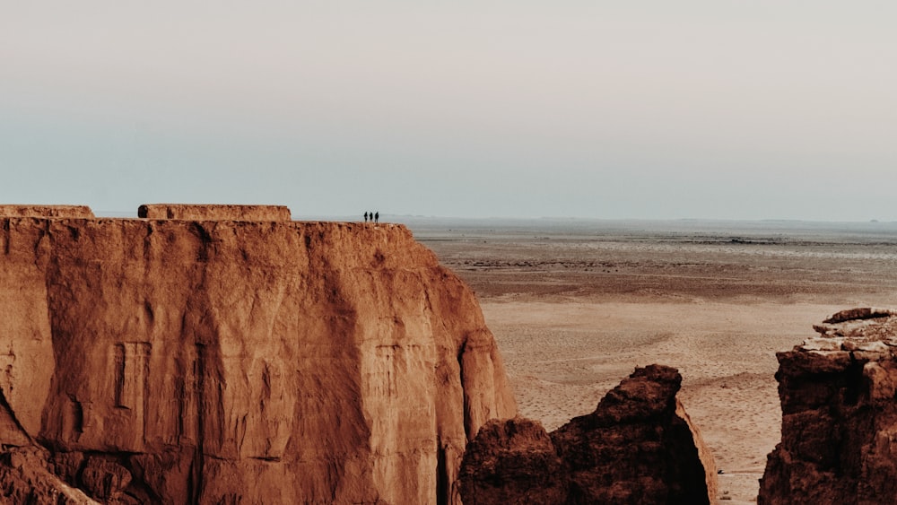 a person standing on top of a cliff in the desert